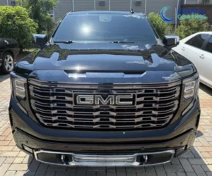 A front-facing view of a black pickup truck showcasing a large chrome grille.
