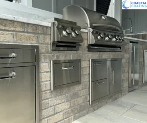 highlighting the polished stainless steel grill inserts and matching cabinets, referencing outdoor kitchen coating