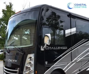 Close-up front corner view of a glossy black Thor Challenger motorhome.